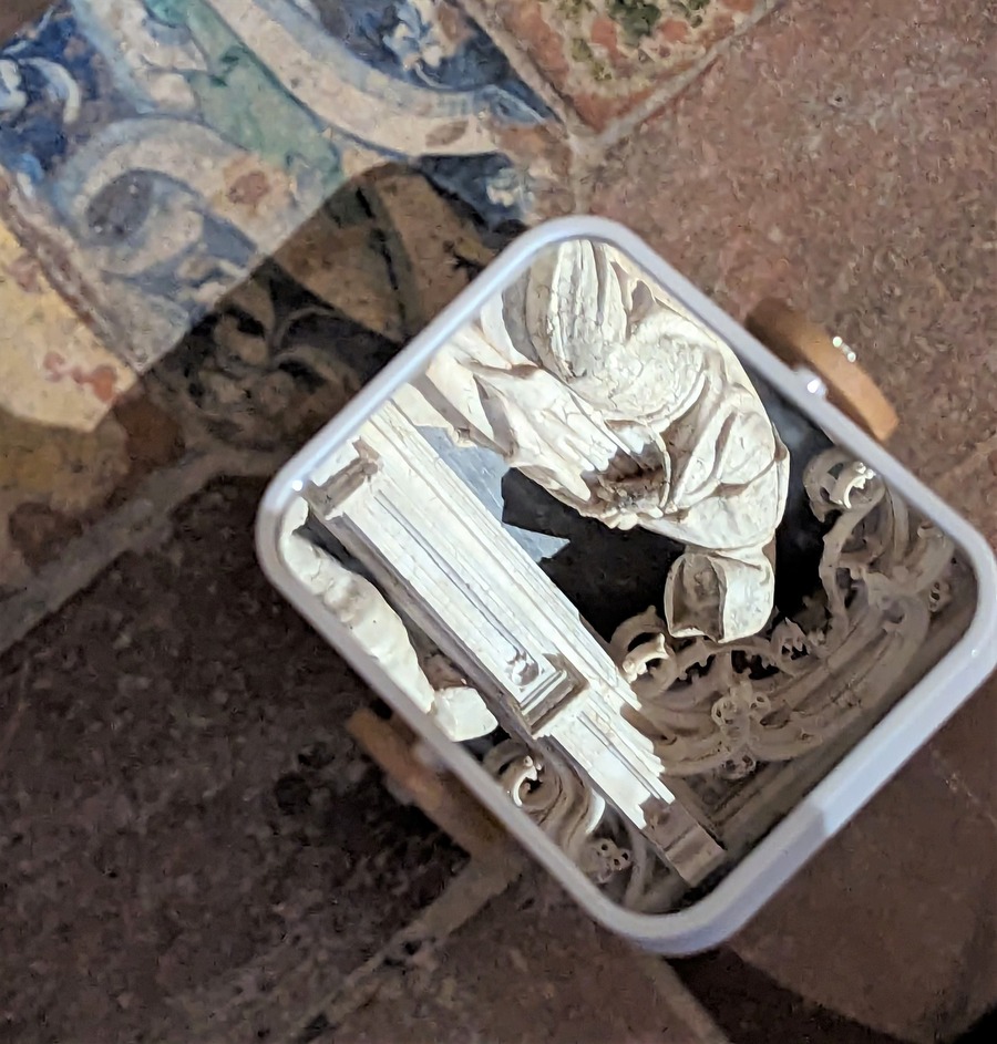 Gros plan sur le dispositif (un miroir permettant de voir la tête d'un pleurant sous sa capuche)